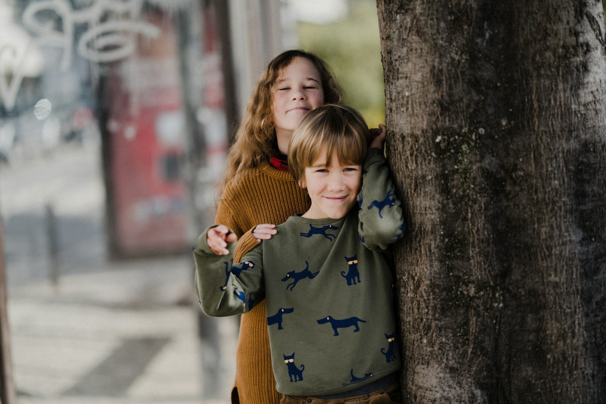 Two happy siblings hugging in cosy knitwear